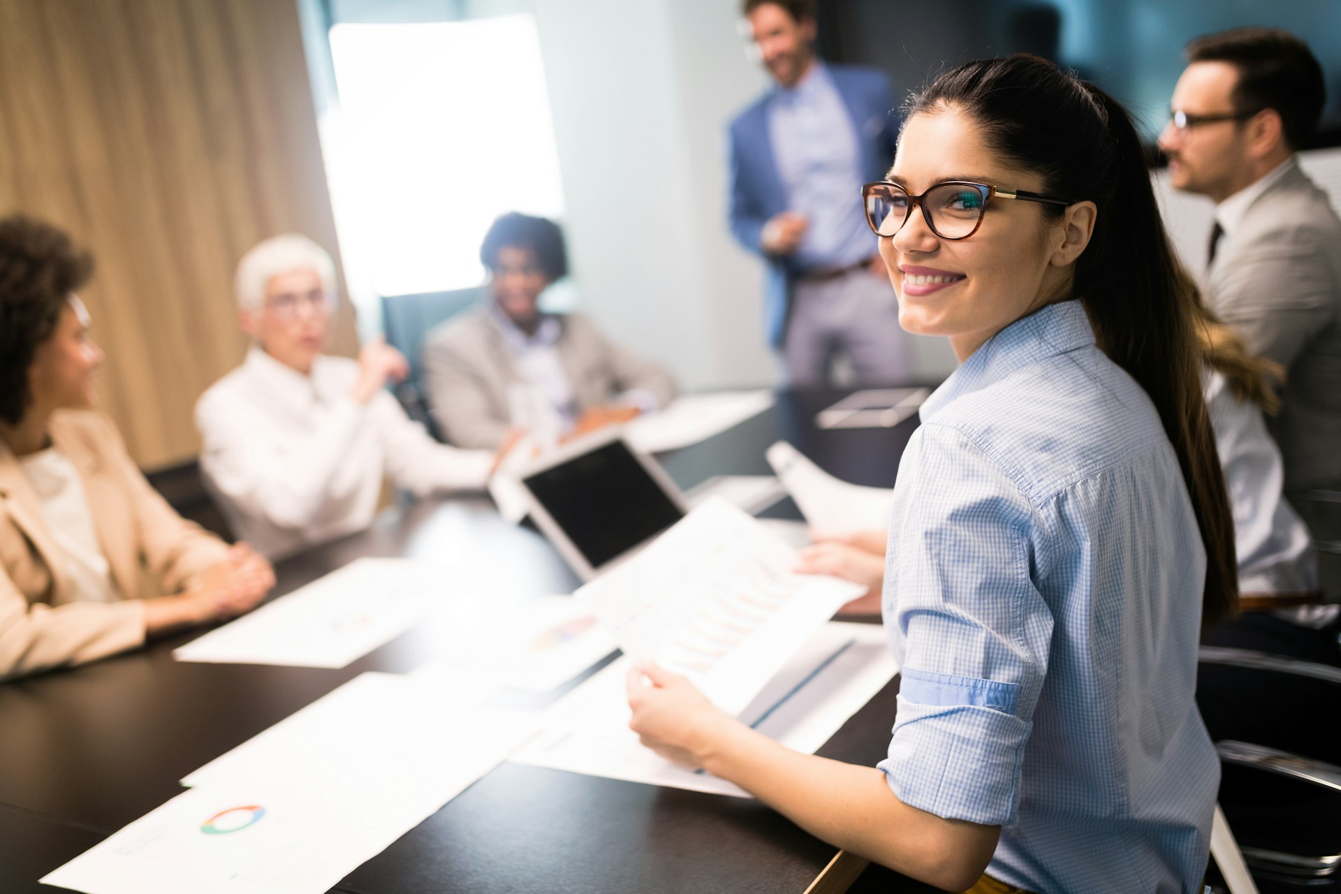 A confident looking women working on a federal contract with co-workers